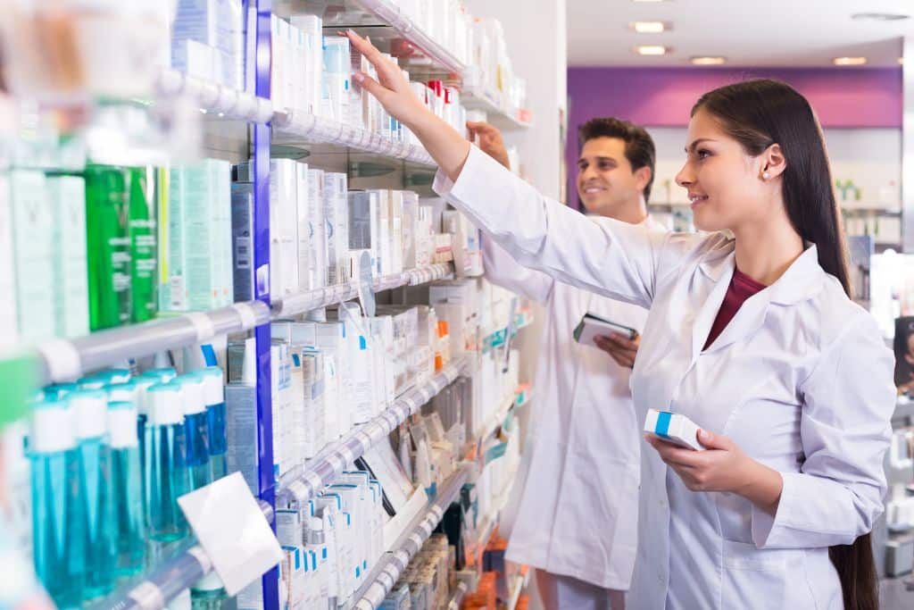 Pharmacist organizing medication shelves in a pharmacy