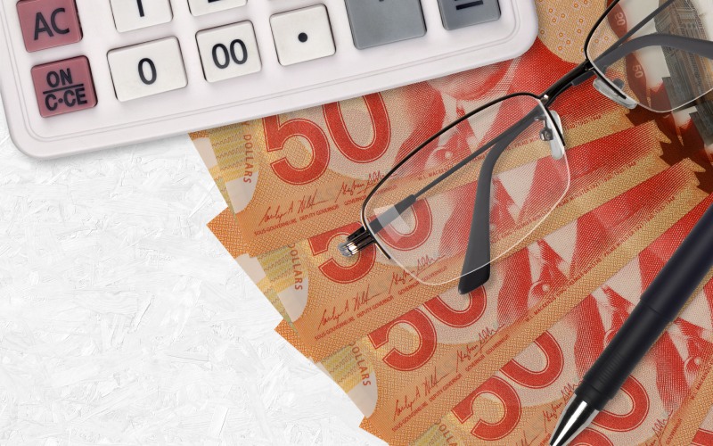 canadian dollars bills-fan-calculator-glasses pen business loan tax