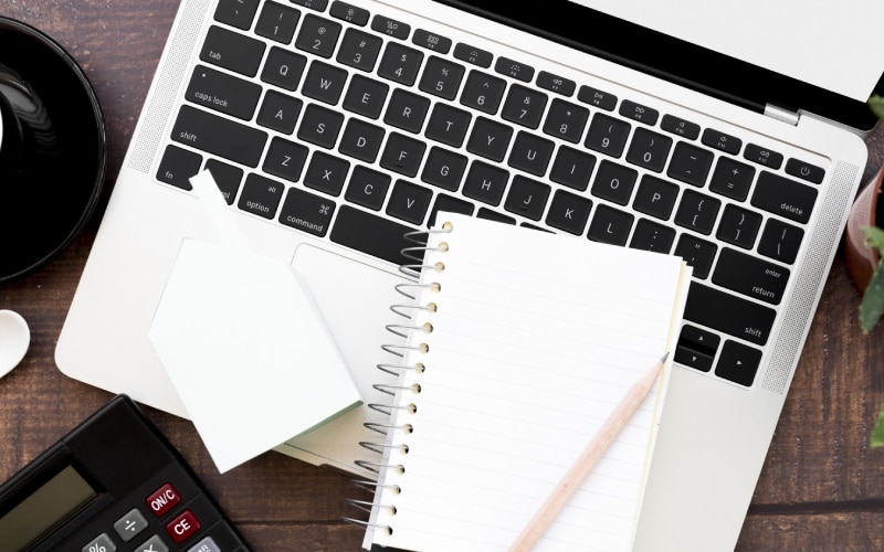 blank spiral notebook with pencil open laptop